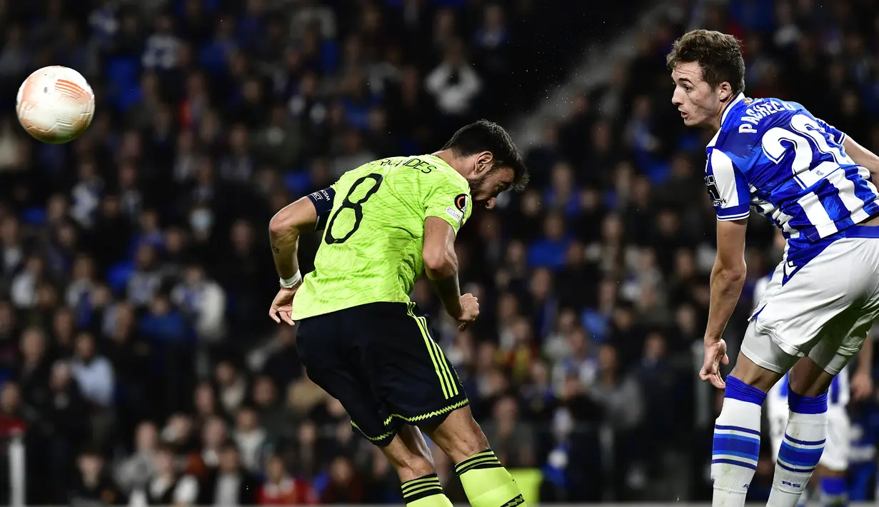 Bek Real Sociedad Jon Pacheco berebut bola dengan gelandang Manchester United atau MU Bruno Fernandes pada laga keenam Grup E Liga Europa 2022/2023 di Anoeta Stadium, Jumat (4/11/2022) dini hari WIB. Cristiano Ronaldo cs pun harus puas finis sebagai runner-up Grup E karena kalah selisih gol. (AP Photo/Alvaro Barrientos)