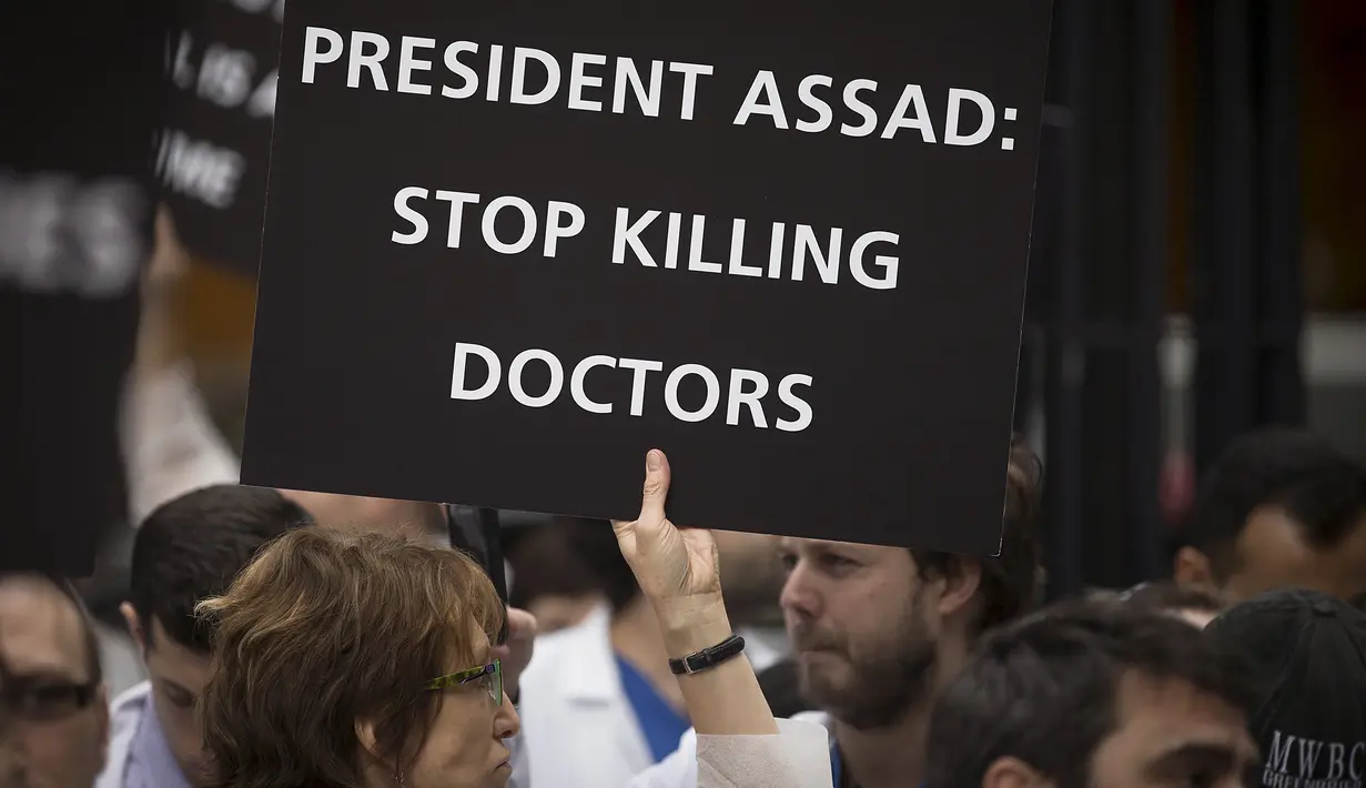 Seorang membawa tulisan dalam aksi protes yang dilakukan di New York, Kamis (29/10/2015).  Hal ini mereka lakukan untuk  menyinggung perihal perang di Suriah yang menewakan 700 petugas medis. (REUTERS/Carlo Allegri)