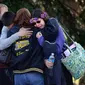Orang tua dan siswa berpelukan di dekat Franklin Regional High School setelah lebih dari selusin siswa ditikam oleh tersangka yang memegang pisau di sekolah di Murrysville, Pa., 9 April 2014. (AP)