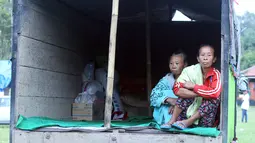 Warga pengungsi Gunung Agung beraktivitas di atas truk yang terparkir di Klungkung, Bali, Sabtu (23/9). Sebagian pengungsi memilih tinggal sementara dan menyimpan barang bawaan di atas truk karena merasa lebih nyaman. (AP Photo/Firdia Lisnawati)