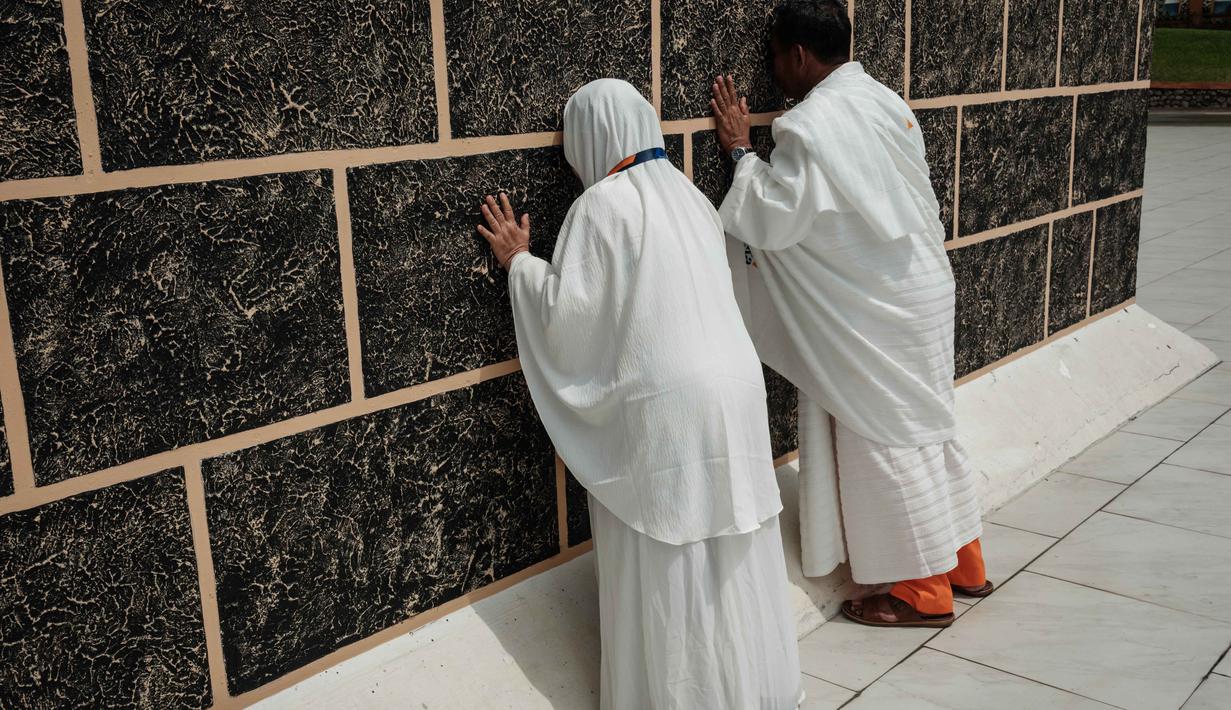 Presiden Prabowo menegaskan bahwa kebijakan tersebut merupakan bagian dari komitmen pemerintah untuk melindungi daya beli masyarakat, khususnya kalangan bawah yang ingin menunaikan ibadah haji. Tampak dalam foto, sepasang suami istri melakukan ritual di replika Ka'bah, saat mengikuti pelatihan di Pusat Pelatihan Manasik Al Mahmudah (AMTC), fasilitas pelatihan Haji yang menampilkan replika situs-situs ziarah utama, di Tangerang Selatan pada 5 April 2026. (YASUYOSHI CHIBA/AFP)
