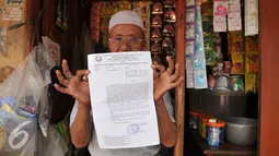 Warga menunjukan surat peringatan ke 3 di Kawasan Bukit Duri, Jakarta, Selasa (20/9). Pemkot Jaksel akan menertibkan bangunan dan permukiman di kawasan Bukit Duri yang berbatasan langsung dengan Sungai Ciliwung. (Liputan6.com/Gempur M Surya)