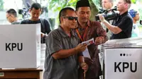 Pemilih disabilitas dibantu pendamping memasukkan surat suara yang telah dicoblos saat mengikuti simulasi Pemilu 2019 di Taman Suropati, Jakarta, Rabu (10/4). Simulasi dilakukan untuk meminimalisir kesalahan dan kekurangan saat pencoblosan pemilu pada 17 April nanti. (Liputan6.com/Johan Tallo)