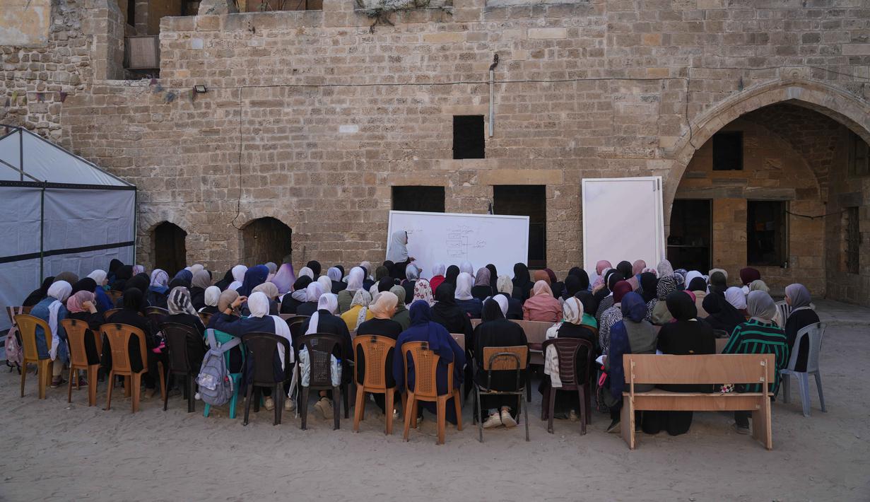 Terdapat sekitar 25.000 siswa bersekolah di ruang belajar sementara yang dikelola UNRWA. Tampak dalam foto, para pelajar SMA Palestina kembali ke kelas, beberapa minggu setelah gencatan senjata diumumkan antara Israel dan Hamas, di Sekolah Kamilia di Kota Tua Gaza City, Rabu, 12 November 2025. (AP Photo/Jehand Alshrafi)