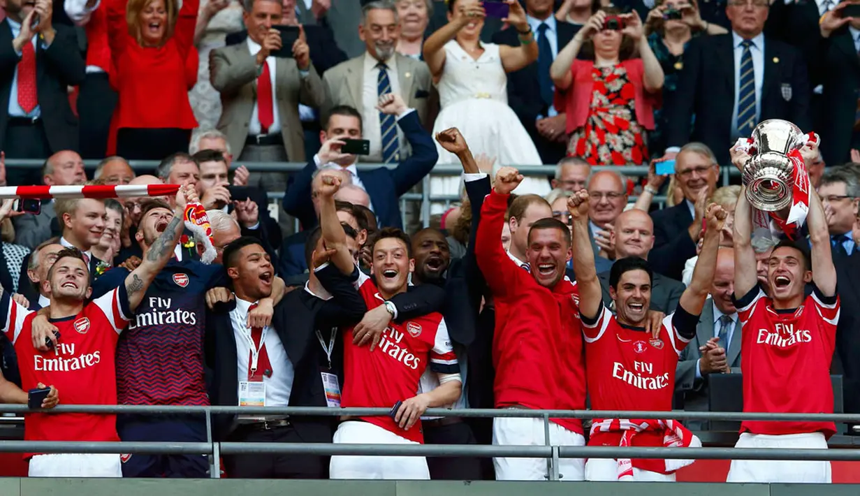 Di tribun kemenangan, para pemain Arsenal mengangkat trofi Piala FA usai menumbangkan Hull City 3-2 di Stadion Wembley, London, (18/5/2014). (REUTERS/Eddie Keogh)
