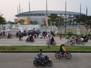 Foto udara memperlihatkan aktivitas warga di jalan lingkar kawasan Stadion Pakansari, Kabupaten Bogor, Jawa Barat, Minggu (28/6/2020). Meski area tersebut belum dibuka kembali, namun warga tetap masuk untuk melakukan beragam aktivitas di kawasan tersebut. (Liputan6.com/Helmi Fithriansyah)