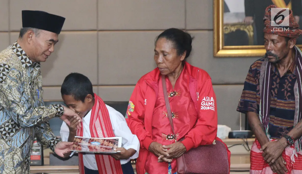 Yohanes “Joni” Ande Kalla menerima penghargaan dan piagam dari Mendikbud Muhadjir Effendy di Jakarta, Senin (20/8). Joni mendapat beasiswa pendidikan atas aksi patriotnya memanjat tiang bendera pada peringatan HUT ke-73 RI. (Liputan6.com/Herman Zakharia)