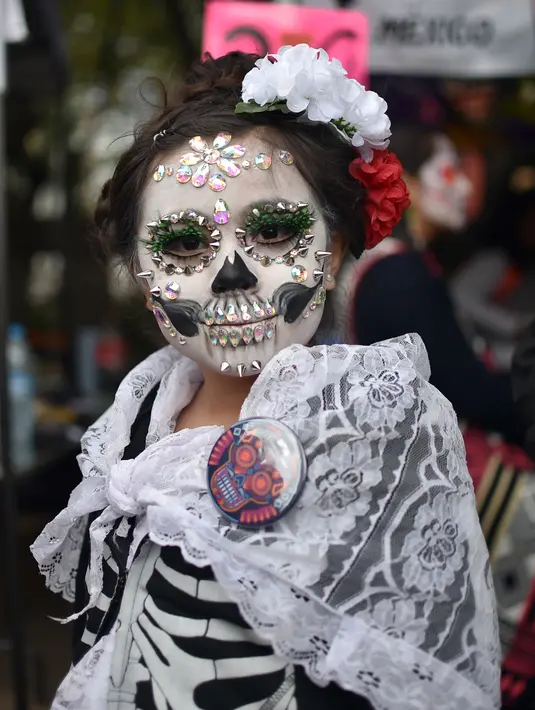 Seorang wanita berpakaian seperti "Catrina" ambil bagian dalam parade Hari Orang Mati di Reforma Avenue, Mexico City, 21 Oktober 2018. Hari kematian ini merupakan tradisi Halloween ala warga Hispanik di Meksiko. (RODRIGO ARANGUA/AFP)
