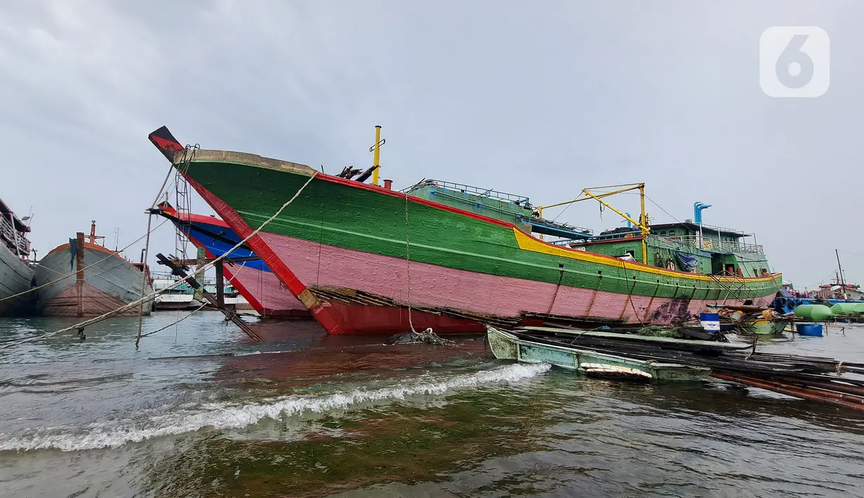 Sejumlah kapal bersandar saat banjir rob di Pelabuhan Muara Baru, Penjaringan, Jakarta Utara, Rabu (28/12/2022). Banjir ROB, hujan deras dan  cuaca buruk melanda kawasan Pelabuhan Muara Baru saat siang menjelang sore hari. (Liputan6.com/Johan Tallo)