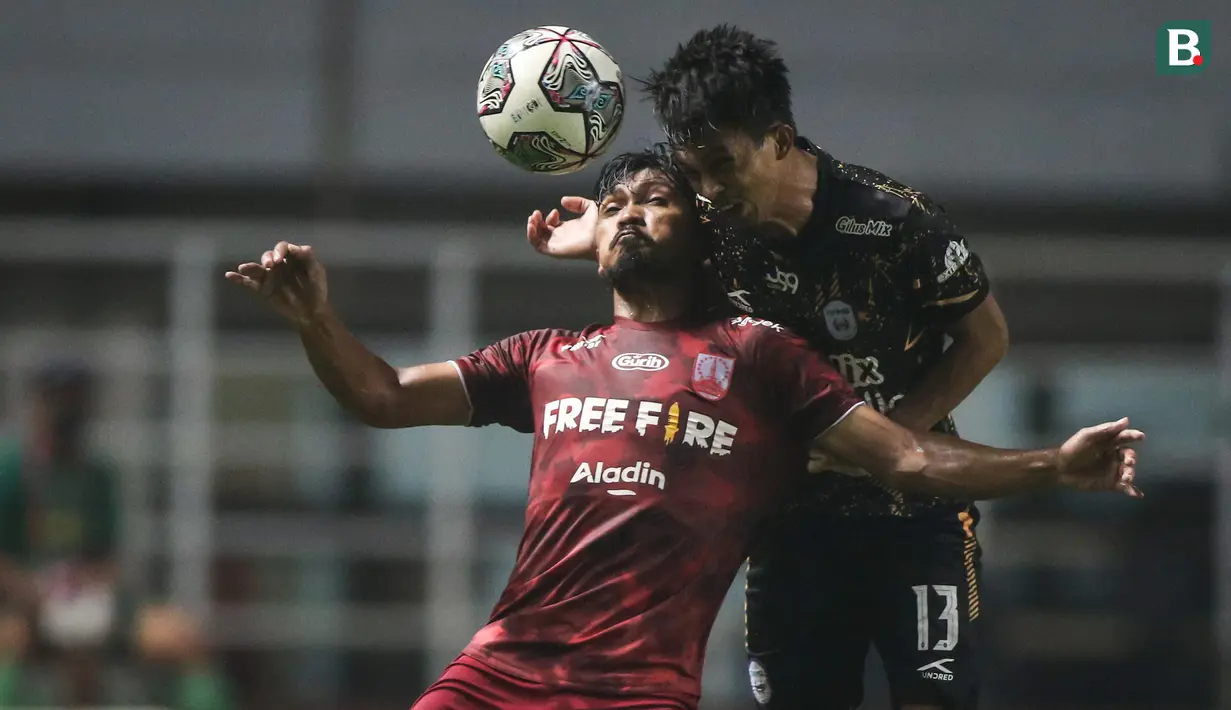 Pemain Persis Solo, Heri Susanto (kiri) berduel udara dengan pemain Rans Cilegon FC, Kurniawan dalam laga final Liga 2 2021 di Stadion Pakansari, Bogor, Kamis (30/12/2021). (Bola.com/Bagaskara Lazuardi)