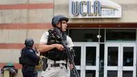 Seorang petugas bersenjata laras panjang mengamankan Universitas California Los Angeles (UCLA) di California, Rabu (1/6). UCLA ditutup sementara setelah terjadi penembakan di satu laboratorium teknik yang menewaskan dua orang. (REUTERS/Patrick T. Fallon)