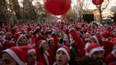Orang-orang mengenakan kostum Sinterklas berkumpul di garis start untuk mengambil bagian dalam Santa Claus Run di Madrid, Spanyol, Minggu (9/12). Ribuan memeriahkan acara yang sudah diselenggarakan sejak 7 tahun yang lalu. (AP/Emilio Morenatti)