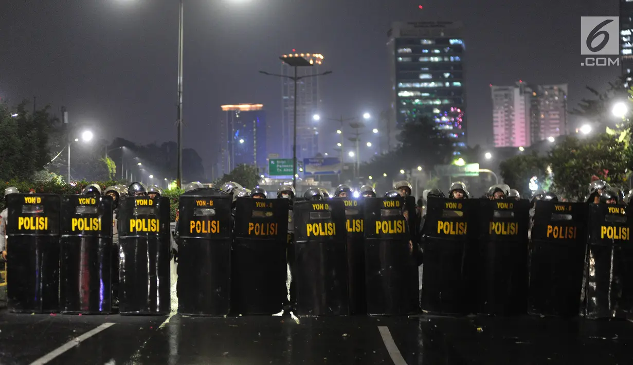 Polisi membuat barikade saat menghalau demonstrasi mahasiswa yang menolak pengesahan RUU KUHP dan revisi UU KPK di depan Gedung DPR/MPR, Jakarta, Selasa (24/9/2019). Hingga malam ini, mahasiswa masih berpencar di kawasan Senayan. (merdeka.com/Arie Basuki)