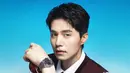 Mengenakan jam tangan stainless Tissot dengan Dial Navy, Lee Dong Wook memilih memadukan kemeja putih lengan panjang dengan vest maroon senada dengan dasinya.  [dok. Tissot]