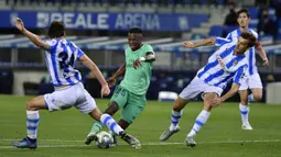 Pemain Real Madrid Vinicius Junior menggiring bola melewati pemain Real Sociedad Robin Le Normand pada pertandingan La Liga di Stadion Anoeta, San Sebastian, Spanyol, Minggu (21/6/2020). Real Madrid memuncaki klasemen sementara La Liga usai mengalahkan Real Sociedad 2-1. (AP Photo/Alvaro Barrientos)