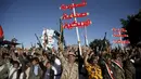 Ratusan kelompok houthi membawa papan yang bertulis "Arab Saudi adalah buatan U.S dan Al-Qaeda adalah buatan U.S selama lakukan demo menentang penyerangan Arab Saudi ke Yaman, Jumat, (20/11). (REUTERS/Khaled Abdullah)