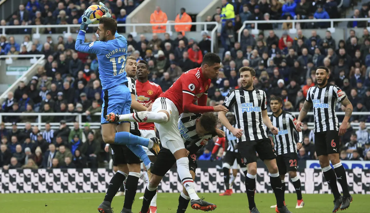 Martin Dubravka (kiri) mengamankan bola dari sundulan pemain Manchester United, Chris Smalling (tengah) pada laga Premier League di St James' Park, Newcastle, (11/2/2018). Necastle menang 1-0 atas Manchester United. (AFP/Lindsey Parnaby)