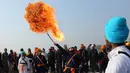 Seorang prajurit Sikh India menyemburkan api saat menampilkan atraksi selama prosesi keagamaan menjelang ulang tahun kelahiran Guru Gobind Singh di Jammu, India (2/1). (AP Photo / Channi Anand)