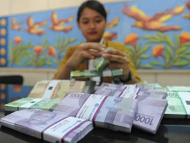 Teller menghitung uang pecahan kecil di kantor cabang Bank BJB di Melawai, Jakarta (7/6). Mengantisipasi kebutuhan dana masyarakat di bulan Ramadan dan Lebaran, pemerintah telah mengalokasikan uang tunai sebesar Rp 188,2 Triliun. (Merdeka.com/Arie Basuki)