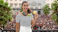 Tunggal putri Spanyol, Carolina Marin, menunjukkan medali emas yang diperolehnya di Olimpiade Rio 2016 kepada warga Huelva, Kamis (25/8/2016) waktu setempat. (huelvaya.es)