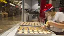 Seorang staf toko kue yang mengenakan pelindung wajah membuat kue tart telur (egg tart) di Square One Shopping Center di Mississauga, Ontario, Kanada  (9/10/2020). Tingkat pengangguran di Kanada pada September turun menjadi 9 persen dari 10,2 persen pada Agustus. (Xinhua/Zou Zheng)