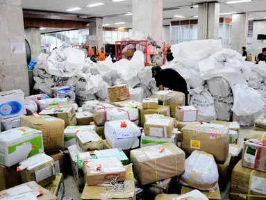 Petugas menata paket kiriman yang baru tiba di Kantor Pos Pasar Baru, Jakarta, Selasa (1/7/14). (Liputan6.com/Faizal Fanani)