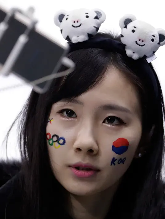 Fans wanita Korea Selatan berselfie sebelum pertandingan babak penyisihan hoki wanita antara Swedia dan gabungan Korea di Olimpiade Musim Dingin 2018 di Gangneung, Korea Selatan, (12/2). (AP Photo / Julio Cortez)
