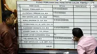 Petugas menulis perolehan suara pada pleno pemilihan dan penetapan Capim KPK di ruang rapat Komisi III DPR RI, Senayan, Jakarta, Jumat (13/9/2019) dini hari. Calon Pimpinan KPK Irjen Pol Firli Bahuri terpilh sebagai Ketua KPK 2019-2023 dengan perolehan 56 suara. (Liputan6.com/Johan Tallo)