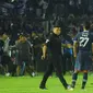 Pemain, ofisial, dan perangkat pertandingan laga Arema Vs Persebaya diberikan kawalan ketat untuk masuk ke dalam ruang stadion karena mereka tak henti-hentinya dilempari botol dan benda-benda lainnya dari tribun Stadion Kanjuruhan, Malang, pada Sabtu (1/10/2022) malam. (Bola.com/Iwan Setiawan)