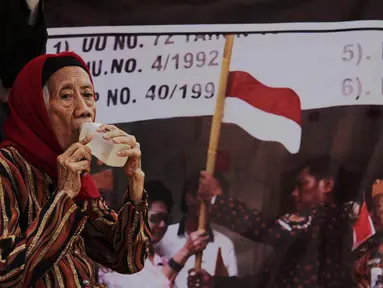 Janda veteran, Ibu Arie Soetanto menggelar aksi di depan Istana Negara, Jakarta, Selasa (9/12/2014). (Liputan6.com/Faizal Fanani)