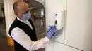 Seorang karyawan hotel membersihkan dispenser cairan pembersih tangan di Hotel Conrad di Kairo, Mesir pada Selasa (2/6/2020). Pemerintah Mesir mulai mengizinkan puluhan hotel beroperasi kembali untuk melayani wisatawan lokal dengan kapasitas dibatasi 50 persen. (Xinhua/Ahmed Gomaa)