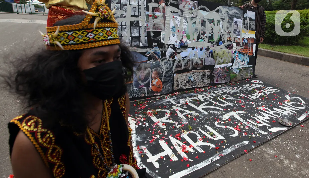 Demonstran melakukan aksi teatrikal saat unjuk rasa di kawasan Bundaran Patung Kuda Arjuna Wijaya, Jakarta, Senin (21/6/2021). Aksi yang dilakukan bertepatan dengan ulang tahun Presiden Joko Widodo ini sebagai bentuk kecaman dan penolakan terhadap revisi UU Minerba. (Liputan6.com/Angga Yuniar)