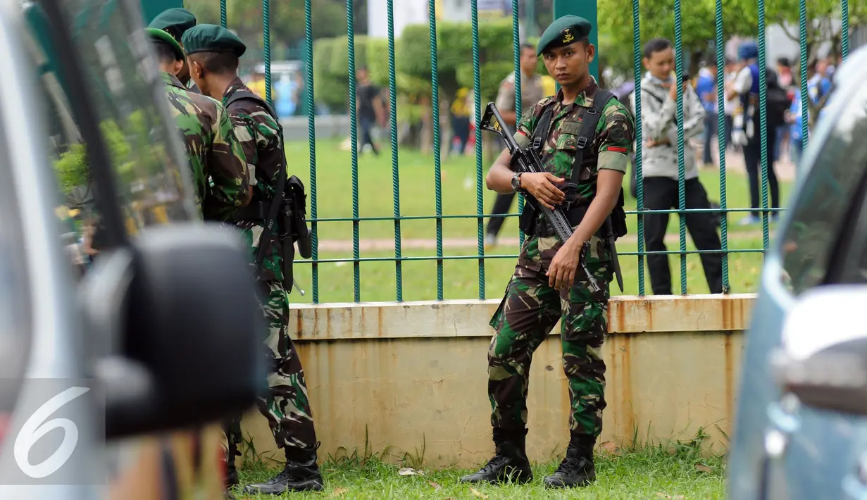 Personil TNI bersenjata lengkap berjaga di sekitar pagar kawasan Stadion GBK Jakarta, Minggu (3/4/2016). Jelang laga final Piala Bhayangkara 2016, 11.000 personil gabungan disiagakan di kawasan Stadion Gelora Bung Karno. (Liputan6.com/Helmi Fithriansyah)