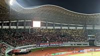 Tribune utara Stadion Patriot Candrabhaga, Bekasi, dipadati suporter yang memberikan dukungan langsung terhadap Timnas Indonesia U-19 saat menghadapi Thailand dalam laga Grup A Piala AFF U-19 2022, Rabu (6/7/2022) malam WIB. (Bola.com/Muhammad Adiyaksa)