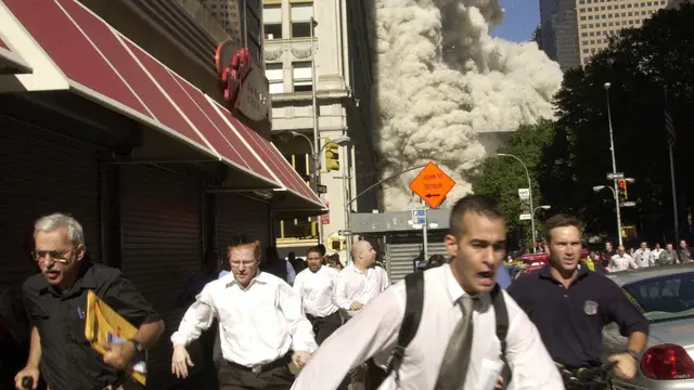 Stephen Cooper, paling kiri, berlari ketika menara selatan WTC New York, AS, runtuh dalam peristiwa 9/11 tahun 2001. Cooper meninggal dunia karena Corona COVID-19, kata keluarganya, menurut The Palm Beach Post. (Credit: AP Photo/Suzanne Plunkett)