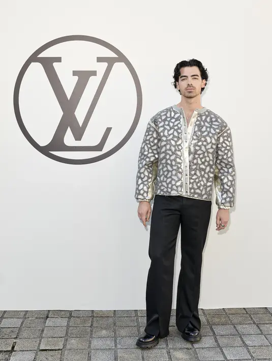 Joe Jonas juga hadir dengan mengenakan atasan silver bertekstur dengan celana panjang dan platform shoes. (Louis Vuitton)