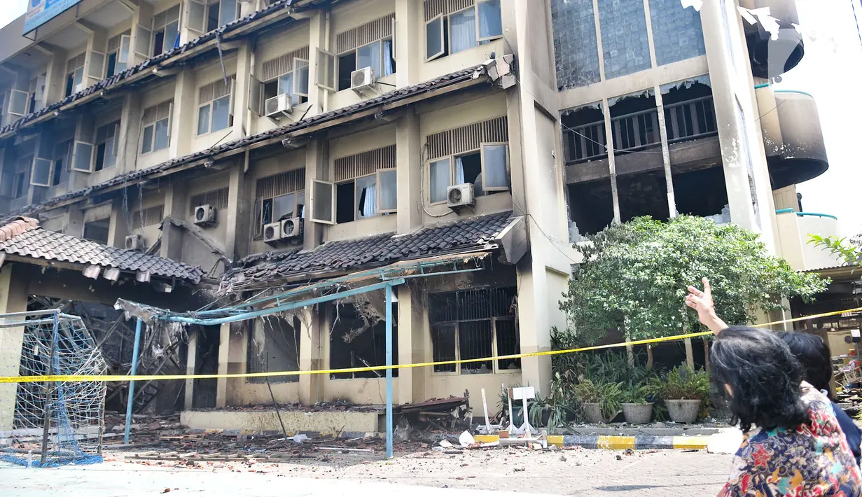 Orangtua murid melihat kondisi gedung SMK Yadika 6 yang ludes dilalap api, Jatiwaringin, Pondok Gede, Kota Bekasi, Jawa Barat, Selasa (19/11/2019). Korban luka dalam kebakaran tersebut rata-rata mengalami patah tulang karena melompat dari lantai atas gedung sekolah. (merdeka.com/Iqbal Nugroho)