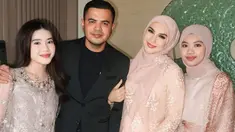 Irish Bella untuk pertama kalinya membagikan momen kondangan bersama keluarga barunya. Dengan senyum semringah, Irish tampak menggandeng suaminya yang berpenampilan rapi mengenakan setelan jas hitam. Sementara, penampilannya tampak senada dengan dua anak sambungnya. (Liputan6.com/IG/@_irishbella_)