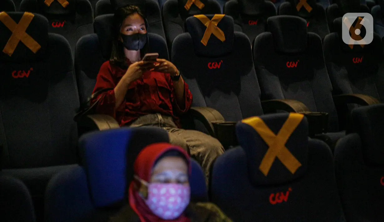 Penonton duduk dengan menjaga jarak di dalam bisokop CGV Grand Indonesia, Jakarta, Kamis (16/9/2021). Pemerintah memberikan kelonggaran dengan memperbolehkan bioskop buka kembali di wilayah berstatus PPKM level 3 dan 2 dengan kapasitas pengunjung 50 persen. (Liputan6.com/Faizal Fanani)