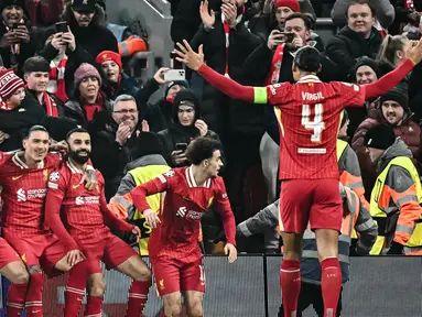 Pemain depan Liverpool, Mohamed Salah (tengah) merayakan golnya bersama dengan rekan setimnya saat laga matchday 7 League Phase Liga Champions 2024/2025 melawan Lille LOSC yang digelar di Stadion Anfield, Inggris, Selasa (21/1/2025) waktu setempat atau Rabu (22/1/2025) dini hari WIB. (Paul ELLIS/AFP)