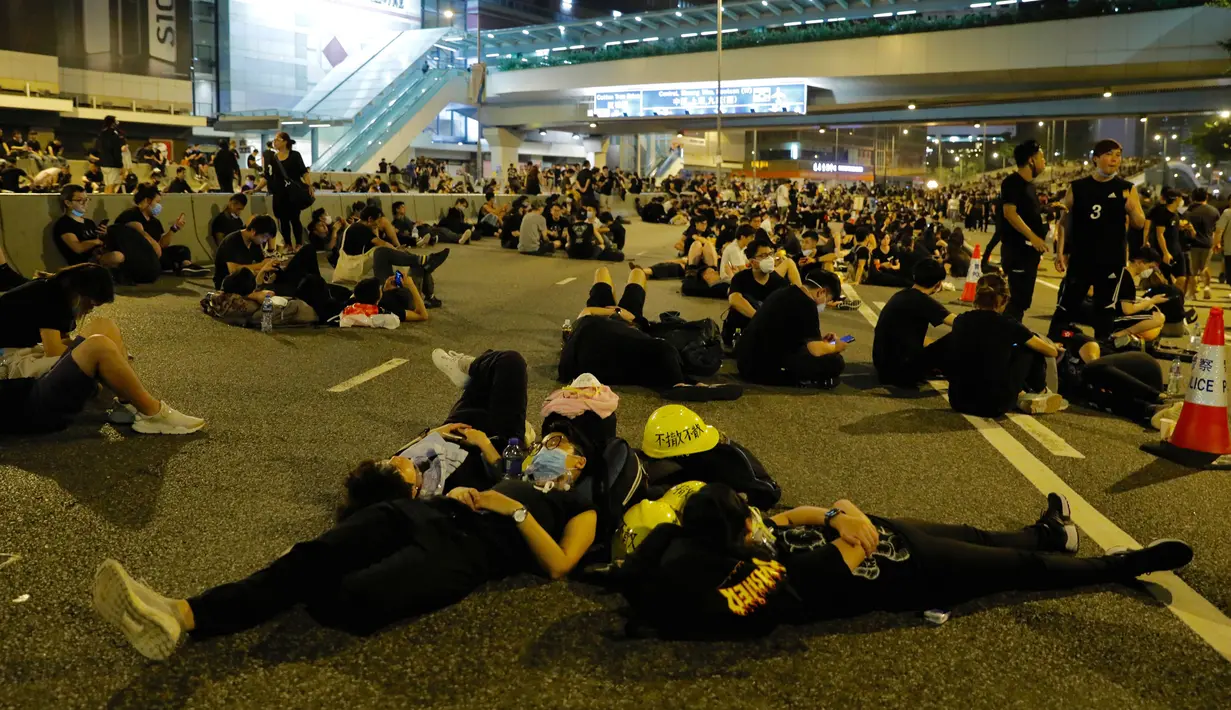 Sejumlah pengunjuk rasa tidur di jalanan dekat Gedung Dewan Legislatif saat menggelar protes terkait RUU Ekstradisi di Hong Kong, Senin (17/6/2019). Sekitar dua juta warga Hong Kong turun ke jalan menentang RUU Ekstradisi. (AP Photo/Vincent Yu)