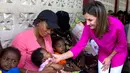 Ratu Spanyol Letizia menyapa seorang bayi perempuan dalam kunjungannya ke rumah sakit di daerah kumuh Soleil, Haiti, 23 Mei 2018. Ini merupakan kunjungan pertama Ratu Letizia ke negara termiskin di benua Amerika tersebut. (AP/Dieu Nalio Chery)