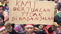  Seorang perempuan memegang poster saat melakukan unjuk rasa bersama ratusan pedagang korban penggusuran di depan halaman kantor Wali Kota Medan.(Antara)