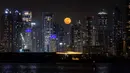 Fenomena Bulan Stroberi bukan hanya suguhan visual, tetapi juga simbol spiritual dan emosional. Tampak dalam foto, bulan purnama yang dikenal sebagai 'Bulan Stroberi' muncul di atas cakrawala Dubai, Uni Emirat Arab pada 11 Juni 2025. (FADEL SENNA/AFP)