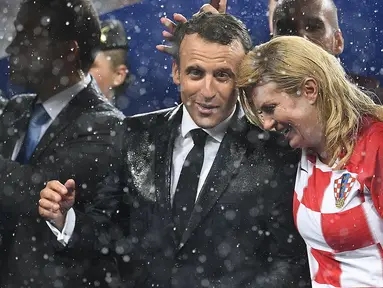 Presiden Prancis Emmanuel Macron (kiri) berbicara dengan Presiden Kroasia Kolinda Grabar-Kitarovic usai laga final Piala Dunia 2018 antara Prancis dan Kroasia di Stadion Luzhnik, Moskow, Rusia, Minggu (15/7). (Franck Fife/AFP)