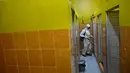Seorang anggota Badan Penanggulangan Bencana Daerah (BPBD) menyemprotkan disinfektan di toilet sebuah Sekolah Menengah Pertama (SMP) dalam rangka program mitigasi pencegahan penyebaran flu burung di Banda Aceh pada Jumat 31 Oktober 2025. Sterilisasi difokuskan pada area asrama baik putri maupun putra. (Chaideer MAHYUDDIN/AFP)