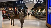 Polisi Thailand berpatroli di dalam pusat perbelanjaan Siam Paragon sebelum dibuka di Bangkok pada tanggal 4 Oktober 2023, sehari pasca penembakan yang menewaskan dua orang. (Lillian SUWANRUMPHA/AFP)