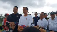 Presiden Jokowi terlihat memakai kaus putih sambil memegang sebuah bola&nbsp;di Ibu Kota Nusantara (IKN), Kalimantan Timur, Selasa (13/8/2024). Tampak Jokowi didampingi Menteri Pemuda dan Olahraga yang juga politikus Partai Golkar, Dito Ariotedjo. (Merdeka.com/Muhammad Genantan Saputra)