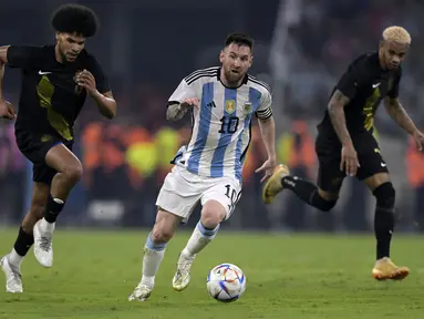 Pemain Timnas Argentina, Lionel Messi menggiring bola melewati pemain Curacao pada laga uji coba internasional yang berlangsung di Stadion Unico Madre de Ciudades, Rabu (29/3/2023) pagi WIB. La Pulga berhasil mencetak hattrick dan membawa timnya menang dengan skor 7-0. (AFP/Juan Mabromata)
