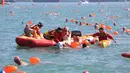 Petugas penyelamat mengangkat seorang perenang dari air dalam keadaan tidak sadar saat mengikuti lomba renang lintas pelabuhan berjarak 1.500 meter di Hong Kong, Minggu (16/10). Perenang itu tewas saat dilarikan ke rumah sakit. (REUTERS/APPLE DAILY)